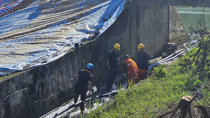 Công nhân đang bơm nước từ hồ ra để giảm áp lực. Ảnh: Minh Bằng