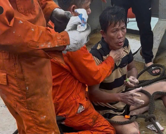 Ông Phạm Duy Quang (áo thun sọc) được các thuyền viên trên tàu Hải Nam 39 ứng cứu.