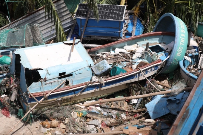 Một chiếc ghe đánh cá vỏ composite bị sóng đánh từ đìa văng lên bờ hư hỏng. Ảnh: Đình Văn