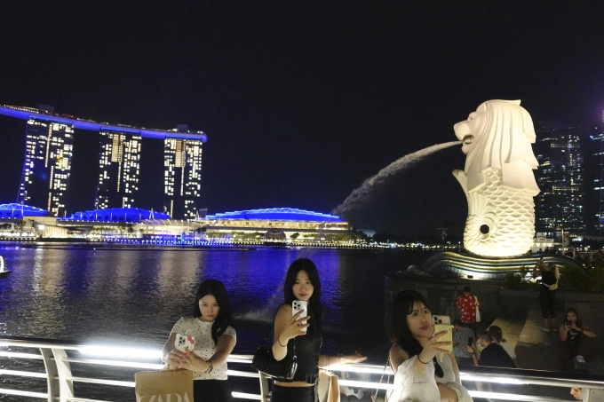 Nhiều người chụp ảnh tại công viên Merlion ở Singapore ngày 11/7. Ảnh: Reuters