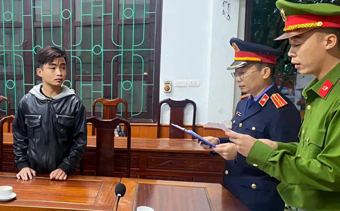 Lê Văn Phương (trái) nghe cơ quan điều tra đọc lệnh khởi tố. Ảnh: Hùng Lê