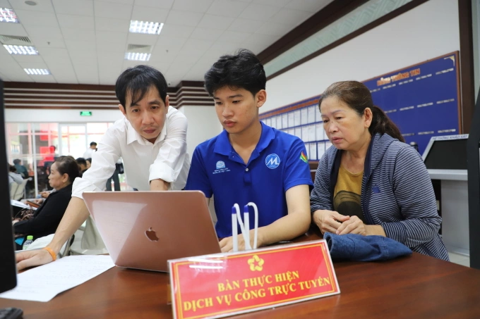 Cán bộ Trung tâm phục vụ hành chính công phường Phú Nhuận, hỗ trợ người dân nhập thông tin lên Cổng dịch vụ công quốc gia, ngày 23/7. Ảnh: Lê Tuyết