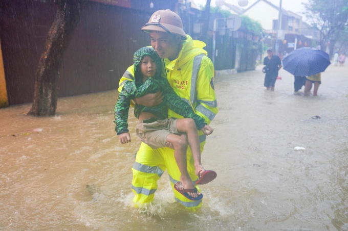Công an hỗ trợ người dân phường Hội An sơ tán trong mưa lũ trên đường Phan Châu Trinh, chiều 27/10. Ảnh: Nguyễn Đông