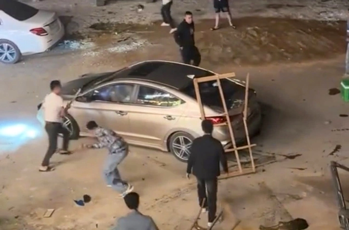 Ôtô của Hùng bị bao vây, đập phá sau khi tông người, tối 10/11. Ảnh: Hùng Lê