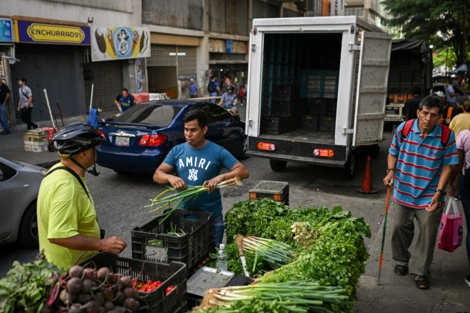 Người dân Venezuela hỏi mua rau tại một quầy bán rau dạo ở khu dân cư La Candelaria tại Caracas ngày 13/11. Ảnh: AFP
