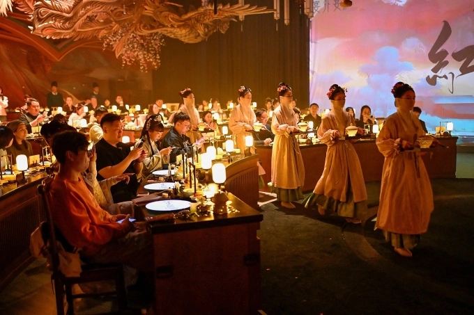 Nhân viên phục vụ ăn mặc, trang điểm theo chủ đề cổ đại bê thức ăn tới bàn cho thực khách trong nhà hàng ở Bắc Kinh ngày 2/11. Ảnh: AFP