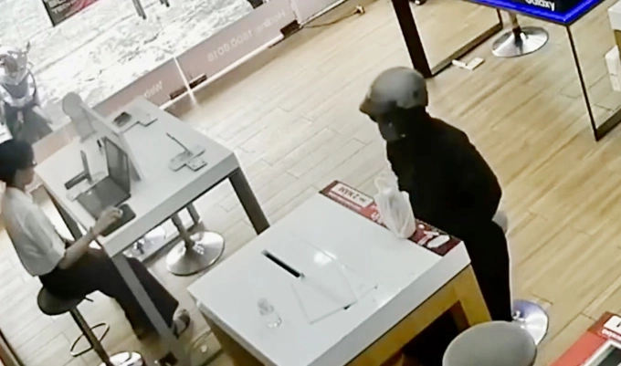 Bùi Thị Thanh Thúy ngụy trang, che mặt đi mua điện thoại. Ảnh: Công an TP HCM