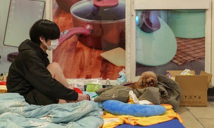 Một cư dân mất nhà cửa nghỉ ngơi trên chiếc nệm được quyên góp tại hành lang bên trong trung tâm mua sắm gần chung cư Wang Fuk Cour hôm 27/11. Ảnh: AFP