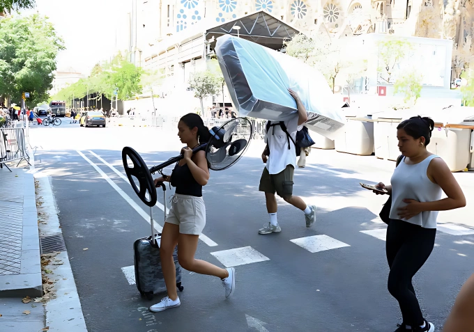 Người dân Tây Ban Nha vận chuyển quạt ở Barcelona. Ảnh: Reuters
