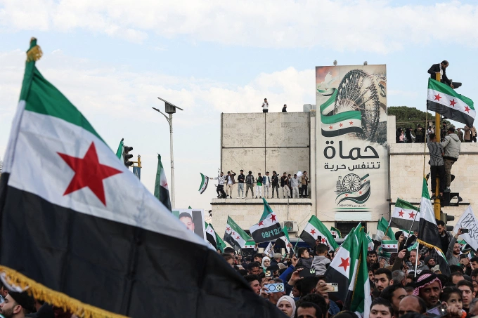 Người dân Syria mang theo cờ tập trung ở thành phố Hama ngày 5/12. Ảnh: AFP