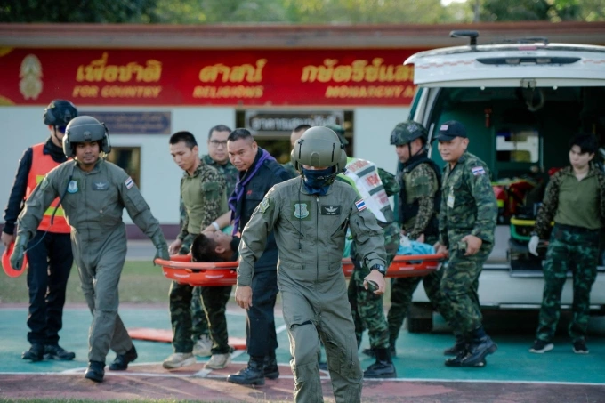 Quân nhân Thái Lan di chuyển hai binh sĩ bị thương sau vụ đấu súng với lực lượng Campuchia ở khu vực biên giới tranh chấp Phu Pha Lek – Phlan Hin Paet Kon, tỉnh Sisaket ngày 7/12. Ảnh: Khaosod