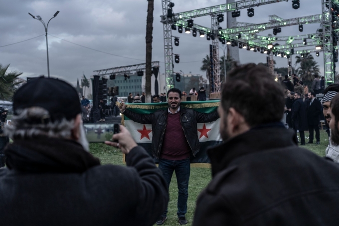 Firas Al-Faqir cầm lá cờ Syria trong buổi lễ kỷ niệm một năm ngày chính quyền Bashar al-Assad sụp đổ. Ảnh: WSJ