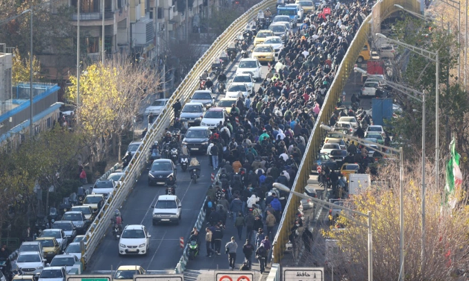 Người biểu tình di chuyển trên cầu tại thủ đô Tehran của Iran hôm 29/12. Ảnh: AFP