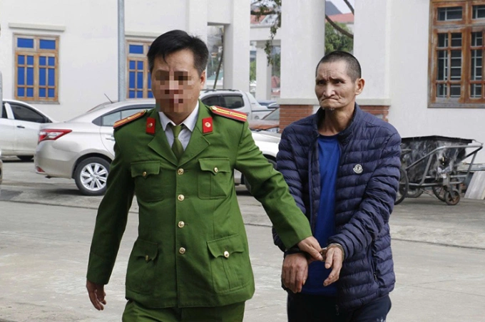 Nghi can Xìa (góc trái), bị cảnh sát dẫn giải về trụ sở. Ảnh: Công an cung cấp