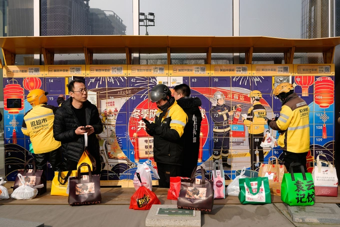 Người giao hàng bỏ bưu kiện vào ngăn kéo tủ có khóa ở Bắc Kinh, Trung Quốc, ngày 15/1. Ảnh: AP