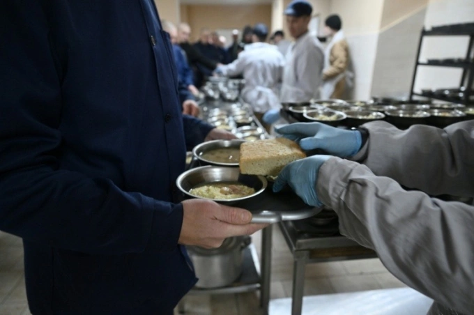 Tù binh nhận suất ăn trưa. Ảnh: AFP