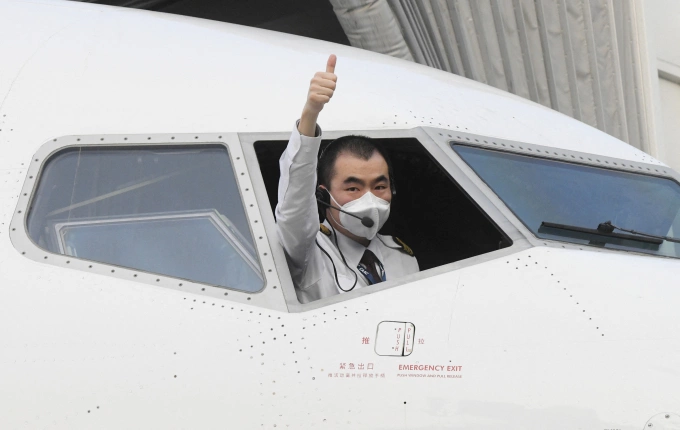 Phi công hãng China Eastern giơ tay trước khi khởi hành từ sân bay thành phố Vũ Hán, tỉnh Hồ Bắc, Trung Quốc tháng 4/2020. Ảnh: AFP