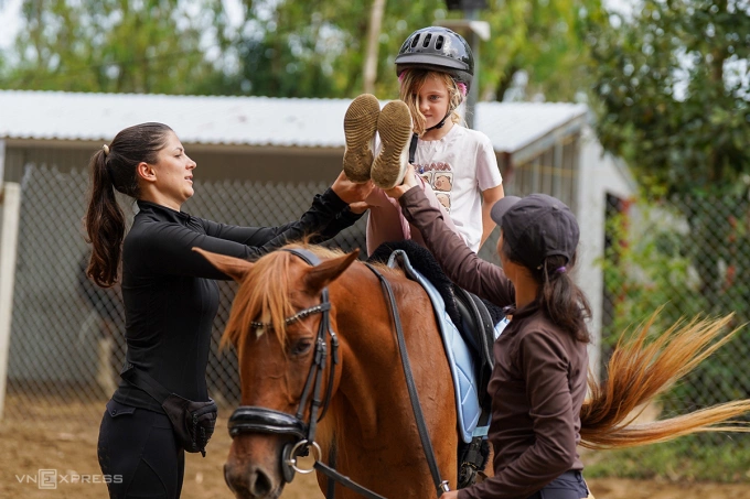 Kseniia trực tiếp hướng dẫn cho cô bé Juno những động tác khó trên lưng ngựa. Ảnh: Nguyễn Đông