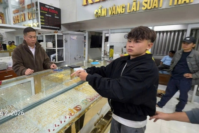 Nghi phạm được đưa đến tiệm vàng Kim Lượng dựng lại hiện trường. Ảnh: Công an cung cấp