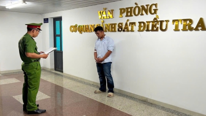 Phạm Quốc Huy nghe đọc lệnh khởi tố bị can. Ảnh: Công an cung cấp