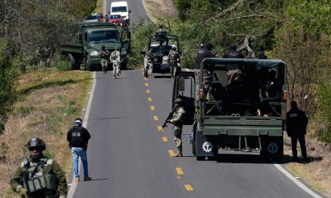 Cảnh sát và quân đội Mexico dọn dẹp một con đường dẫn tới thị trấn Tapalpa sáng 23/2. Ảnh: Reuters