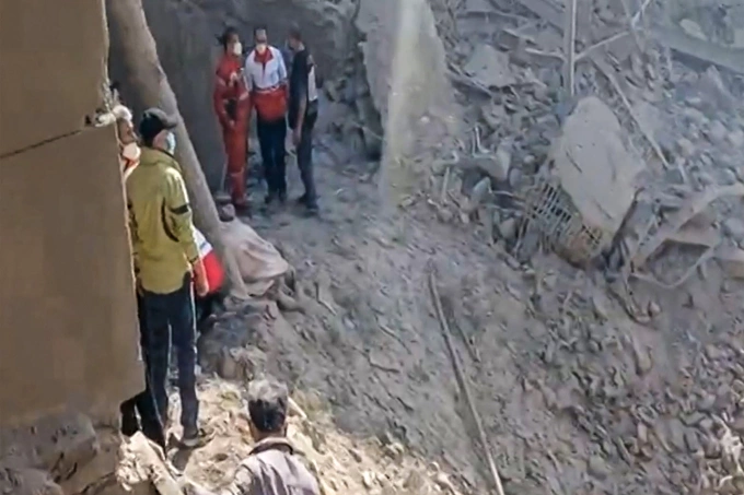 Người dân ở Tehran, Iran, đứng giữa đống đổ nát do đòn tập kích của Israel - Mỹ gây ra ngày 28/2. Ảnh: AFP