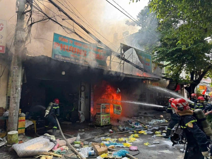 Lính cứa hoả nỗ lực dập lửa cửa hàng và ngăn cháy lan. Ảnh: Minh Bằng