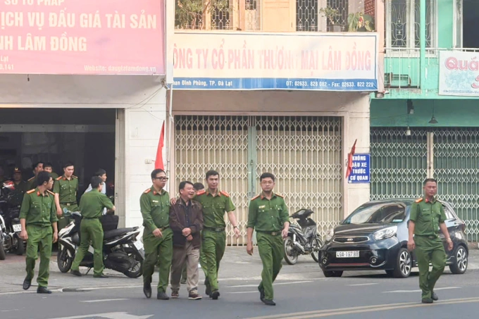 Cảnh sát dẫn ông Tám rời khỏi trụ sở. Ảnh: Hoài Thanh