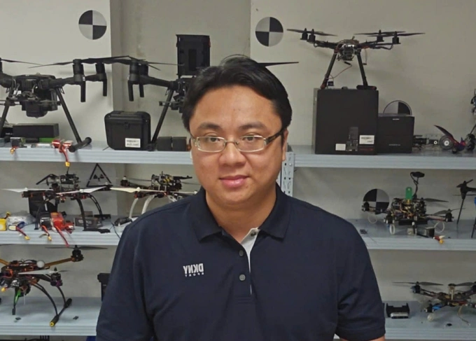 TS. Thiên Minh bên cạnh các robot bay của phòng lab tại Đại học Công nghệ Nanyang. Ảnh: NVCC