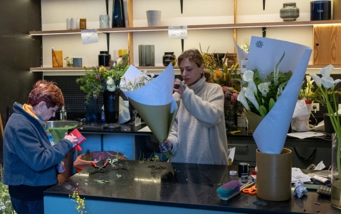 Yael Ben Cnaan bó hoa cho khách trong cửa hàng ở Tel Aviv sáng 1/4. Ảnh: JTA