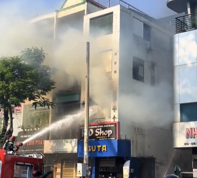 Lính cứu hoả dùng lăng xịt nước dập lửa ở nhà cháy. Ảnh: Minh Bằng