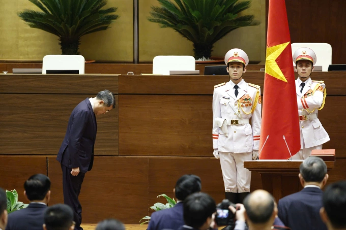 Tân Thủ tướng Lê Minh Hưng cúi chào cờ Tổ quốc trước khi thực hiện nghi thức tuyên thệ. Ảnh: Hoàng Phong