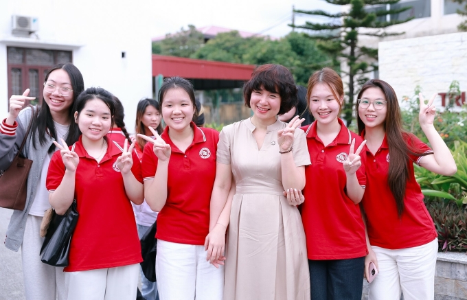PGS. TS Phạm Thu Hương, hiệu trưởng trường Đại học Ngoại thương, cùng các sinh viên. Ảnh: FTU Times