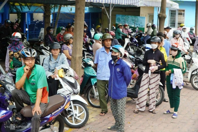 Phụ huynh đợi đón con ở trường Tiểu học Bình Quới Tây, trưa 10/4. Ảnh: Lệ Nguyễn