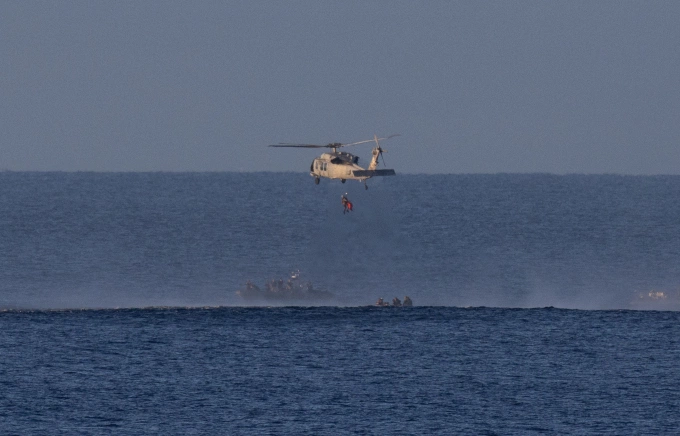 Phi hành gia NASA Reid Wiseman, chỉ huy nhiệm vụ Artemis II, được đưa lên trực thăng quân sự của Mỹ để được vận chuyển đến tàu USS John P. Murtha. Ảnh: NASA