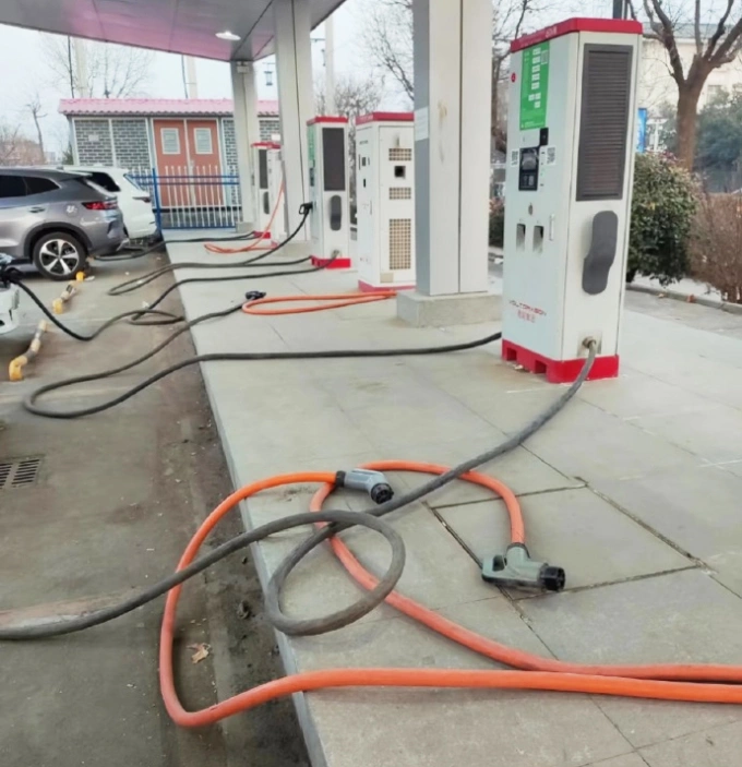 Một số súng sạc thay vì cắm vào trụ sạc lại nằm trên mặt đất tại một trạm sạc xe điện ở Trung Quốc. Ảnh: Weibo