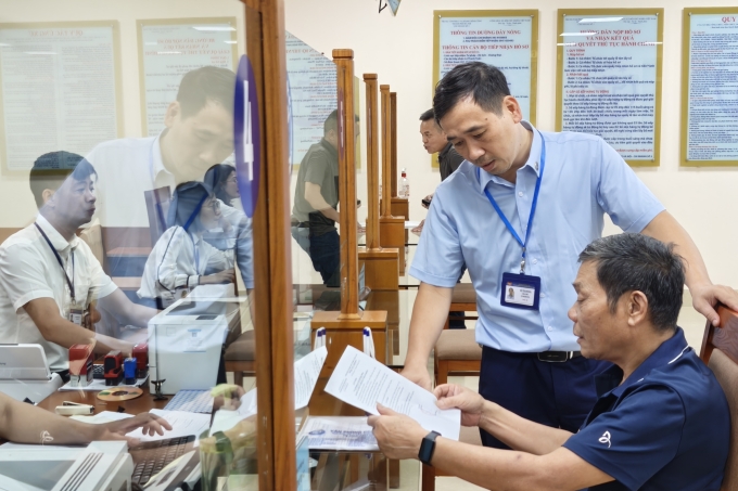 Cán bộ Trung tâm Phục vụ hành chính công thành phố Hà Nội chi nhánh số 3 hướng dẫn người dân sử dụng dịch vụ công. Ảnh: Trọng Đạt