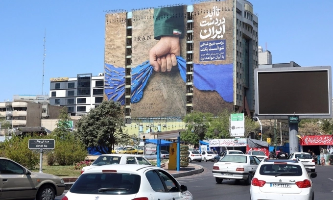 Dòng xe cộ di chuyển qua một bảng quảng cáo khổ lớn đề cập đến eo biển Hormuz với dòng chữ tiếng Ba Tư Mãi mãi trong tay Iran tại thủ đô Tehran, Iran, ngày 15/4. Ảnh: VCG
