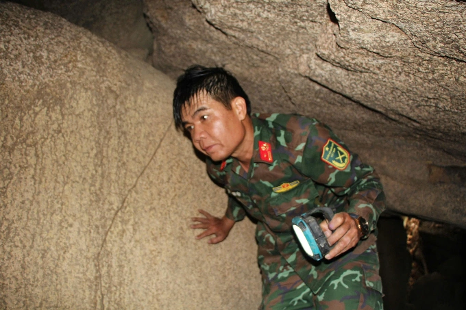 Thiếu tá Nguyễn Ngọc Tiệp, thành viên Đội quy tập mộ liệt sĩ Quân đoàn 34, đi sâu vào hang đá núi Chư Pa tìm kiếm và quy tập liệt sĩ, tháng 4/2026. Ảnh: Kim Thi