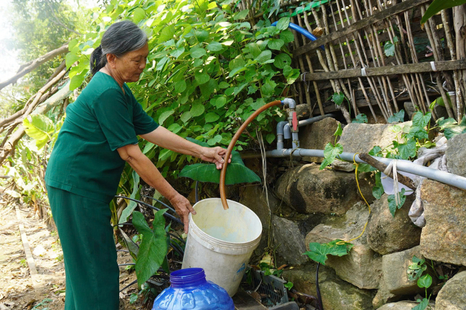 Bà Nguyễn Thị Phúc mang xô ra hứng nước giữa trưa. Ảnh: Trần Hóa