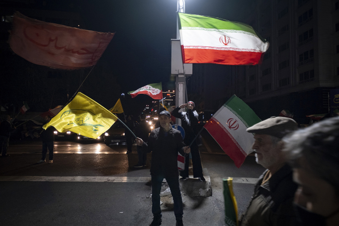 Người Iran vẫy cờ trong cuộc biểu tình ủng hộ chính phủ ở Tehran ngày 24/4. Ảnh: Reuters