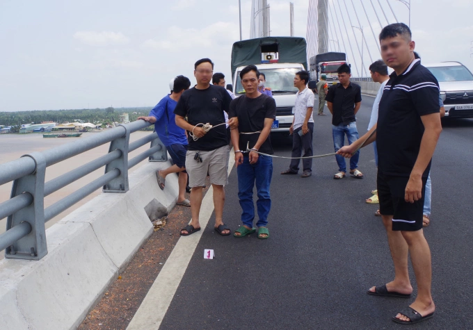 Các trinh sát dẫn giải Lê Văn Cang thực nghiệm hiện trường. Ảnh: Nam An