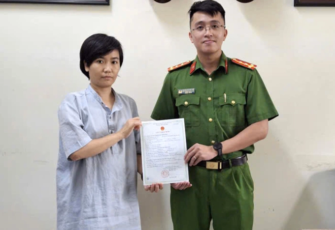 Đại uý Nguyễn Phan Nhật Anh trao giấy khai sinh của bé trai cho người mẹ. Ảnh: Bảo Trân