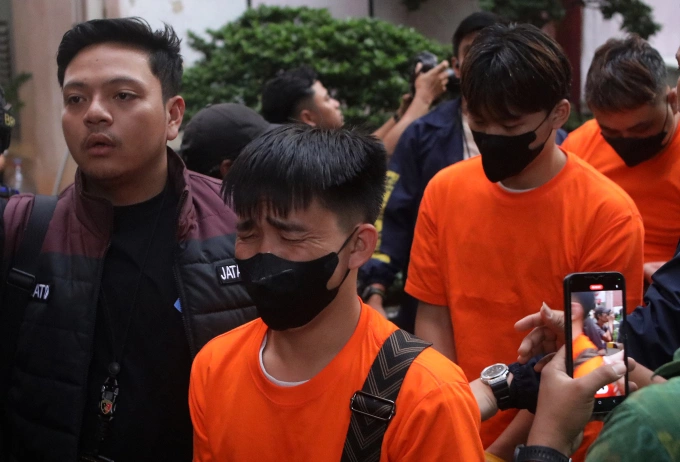 Cảnh sát Indonesia áp giải nghi phạm bị bắt trong cuộc đột kích ổ cá độ trực tuyến ở Jakarta. Ảnh: AP