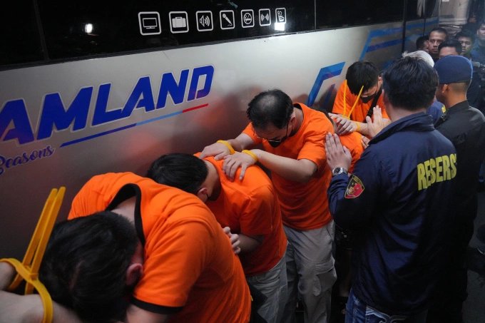 Cảnh sát Indonesia áp giải nghi phạm bị bắt trong cuộc đột kích ổ cá độ trực tuyến ở Jakarta. Ảnh: AP