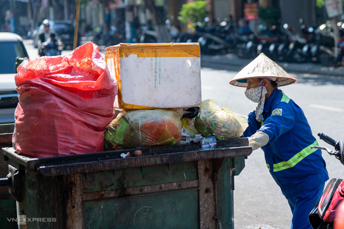 Công nhân Ông Thị Mỹ Linh trong ca làm, rác thải thường vượt thùng do quá tải ở khu vực trung tâm thành phố. Ảnh: Nguyễn Đông