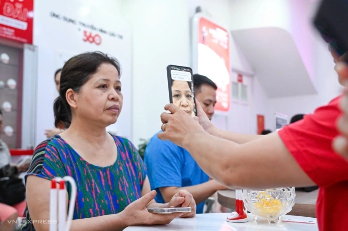 Một người dân đang được nhân viên nhà mạng xác thực thông tin, sinh trắc học ảnh khuôn mặt. Ảnh: Giang Huy
