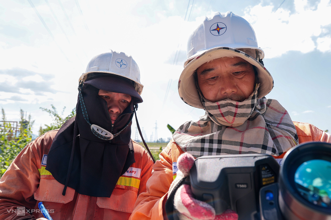 Ông Hà (góc phải) cùng đồng nghiệp làm việc dưới công trình đường dây 500 kV, ngày 27/5. Ảnh: Đức Hùng