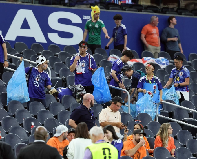 CĐV Nhật Bản dọn dẹp rác sau trận đấu ở sân Dallas, bang Texas, Mỹ. Ảnh: AFP