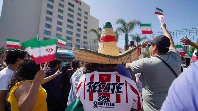 Người Mexico vẫy cờ Iran chào đội bóng Iran tại Tijuana. Ảnh: Reuters